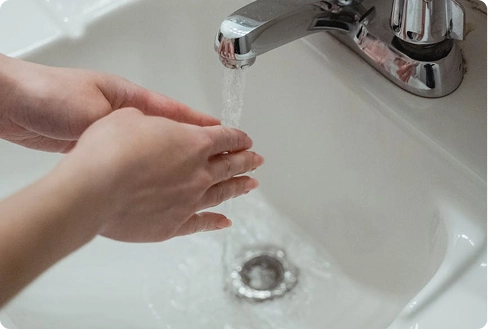 Signs Your Plumbing Needs Attention 3 Running water from faucet with hands under stream, Bridge Plumbing & HVAC plumbing service.