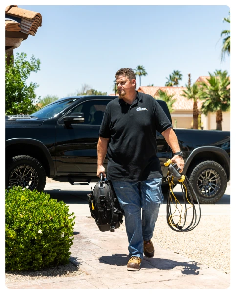 Maintenance Plan 37 Robert Bridge walking with tool bag and cables in residential driveway.