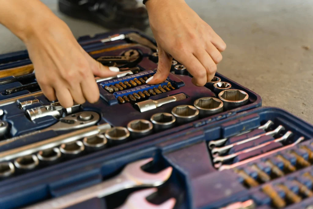 Hands selecting tools from a mechanic’s toolkit with wrenches and sockets. Plumbing Services