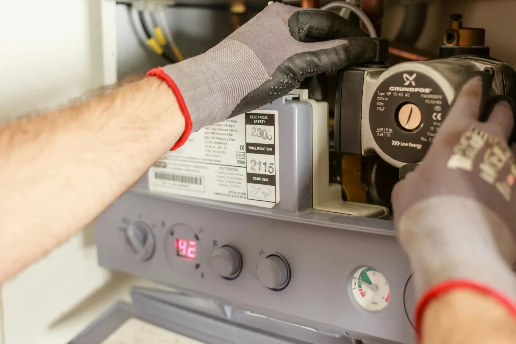 AC Repair 34 Technician adjusting heating system controls with gloved hands.