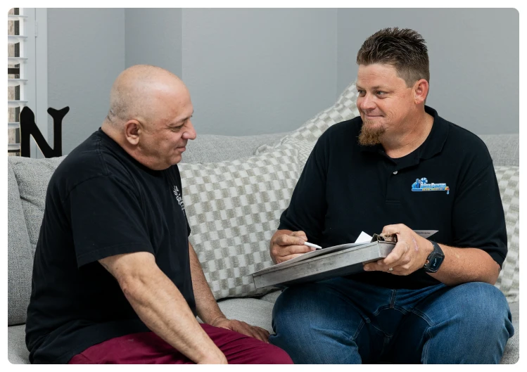 Financing 30 Robert Bridge discussing paperwork with a customer on a living room couch.