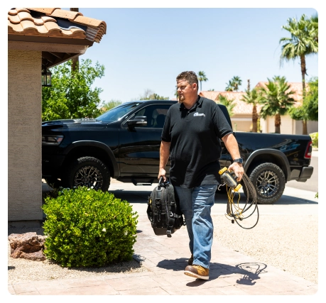 Special Offers 49 Robert Bridge carrying a tool bag and cables while walking toward a home.