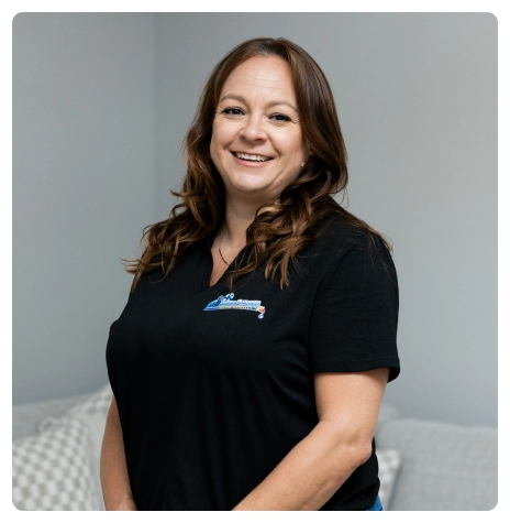 Career 30 Amy Bridge smiling indoors wearing a black company polo shirt.